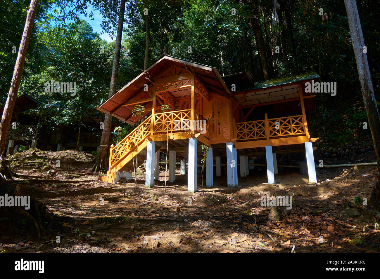 Looking at a restored, yellow cottage near the waterfall at Gunung Stong State park. In DaBong, Kelantan, Malaysia. Stock Photo