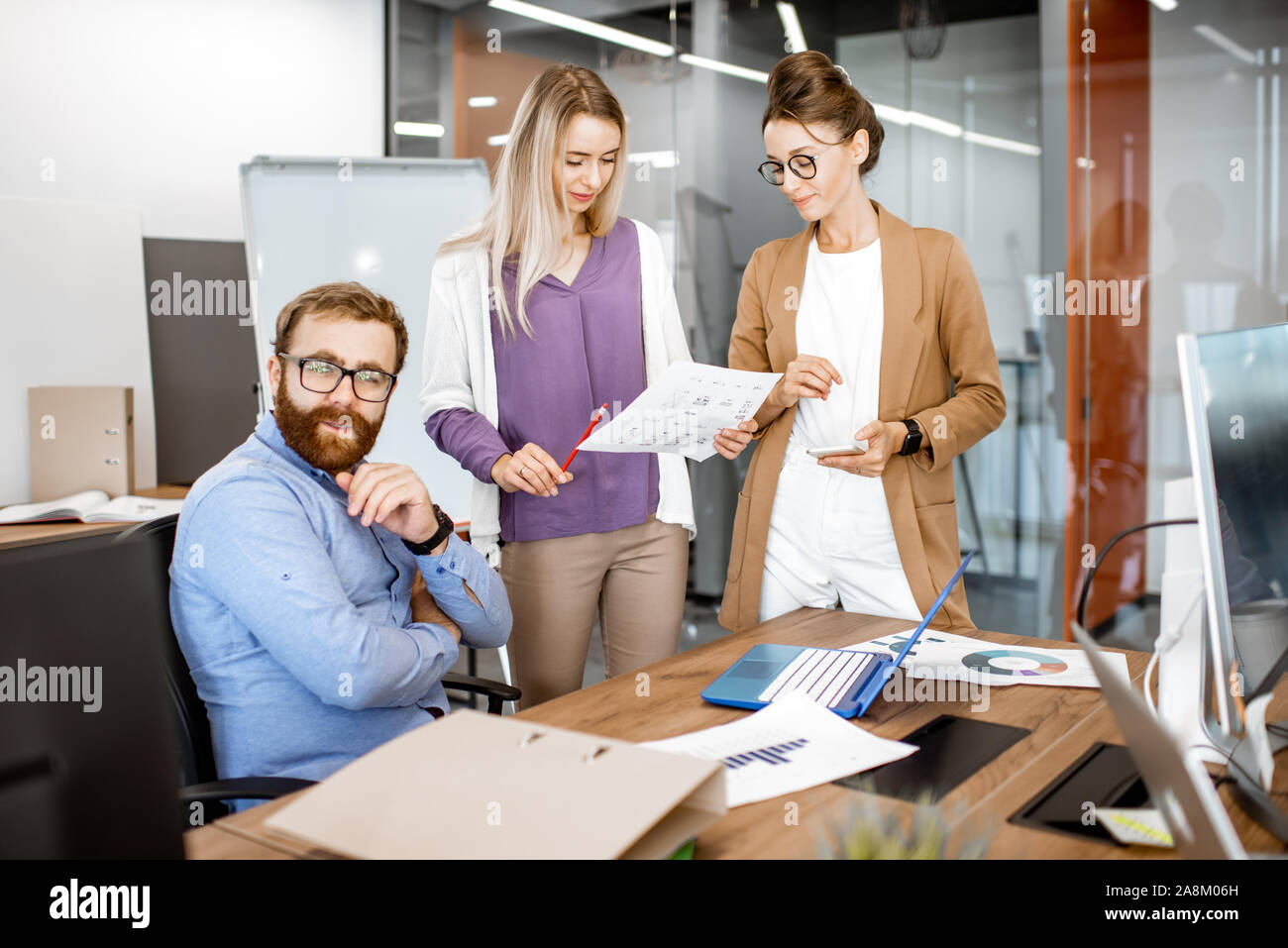 Group of diverse colleagues working in the office, having discussion or small conference at the working place Stock Photo