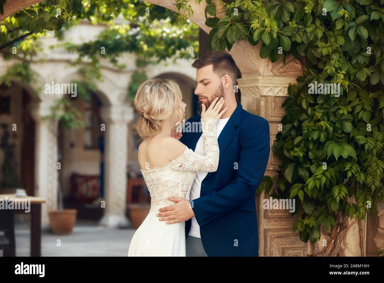 Love story of a woman and a man. Loving couple embraces, a beautiful Oriental couple. A man in a jacket and a girl in a long luxurious light dress Stock Photo