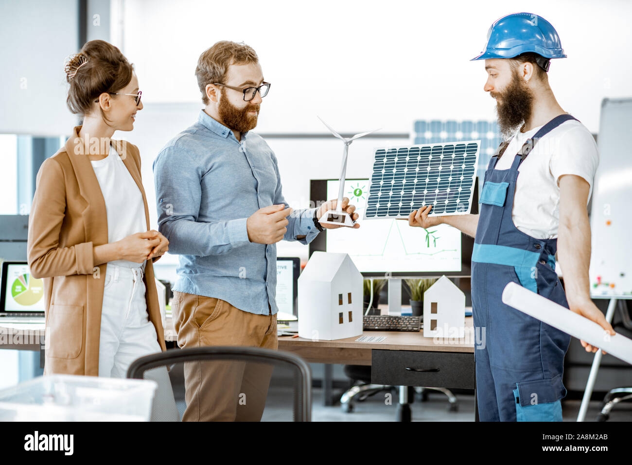 Young engineers and workman working on a project of alternative energy ...