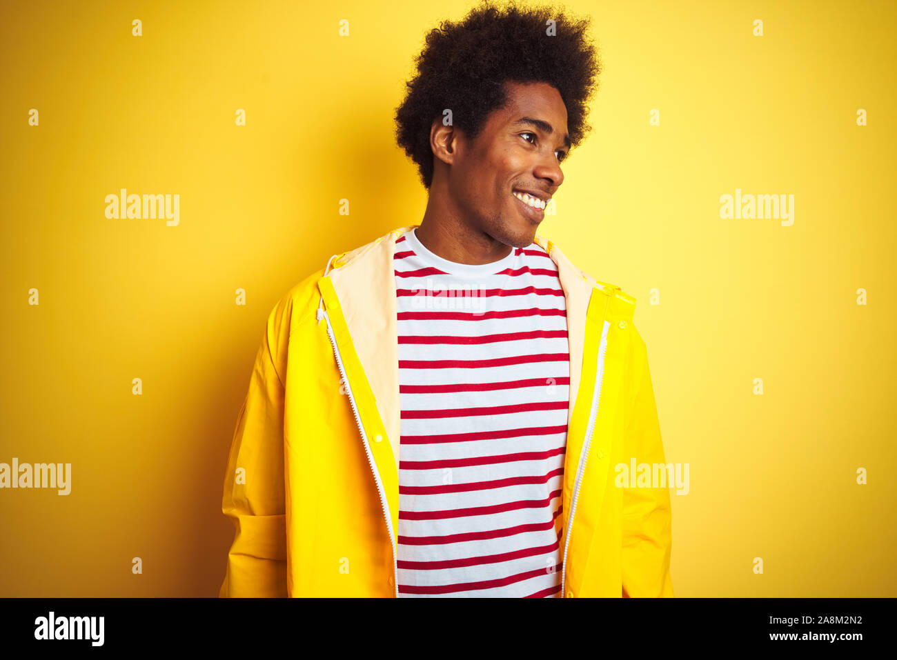 African American Man With Afro Hair Wearing Rain Coat Standing
