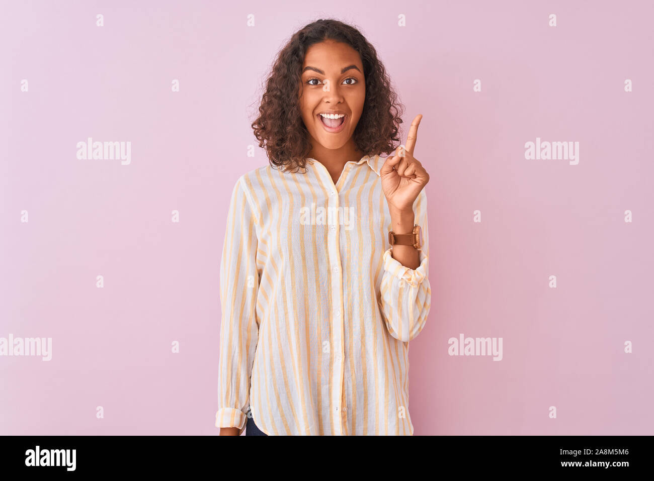 Young Brazilian Woman Wearing Striped Shirt Standing Over Isolated Pink