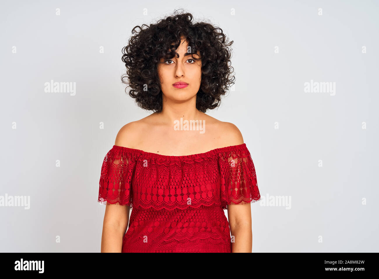 Young Arab Woman With Curly Hair Wearing Red Dress Standing Over