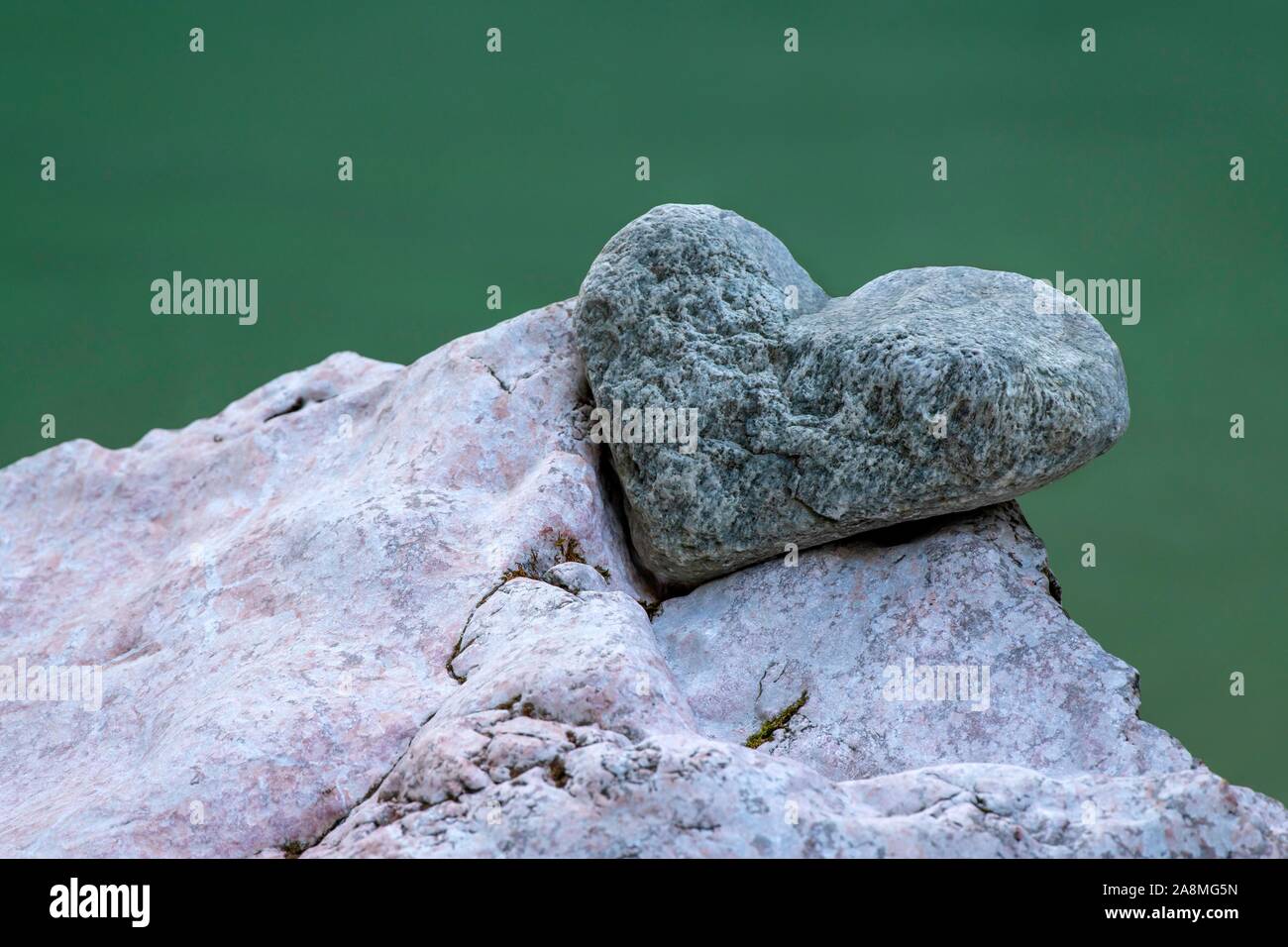 Stone in the shape of a heart lies in the notch of another stone, Tiefenbachklamm, Kramsach, Tyrol, Austria Stock Photo
