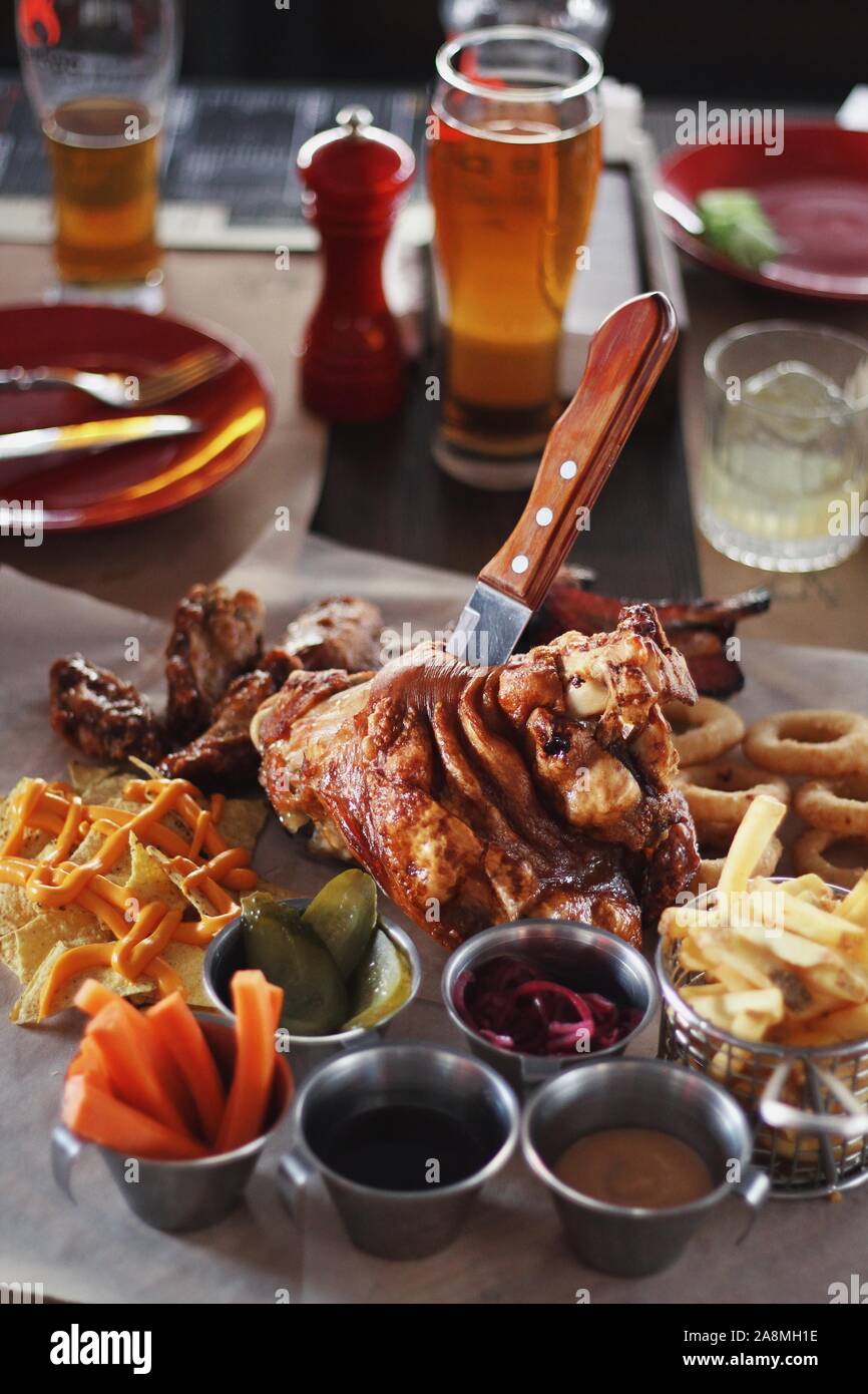 Pork knuckle with carrot, cucumber, sauce and light filtered beer on