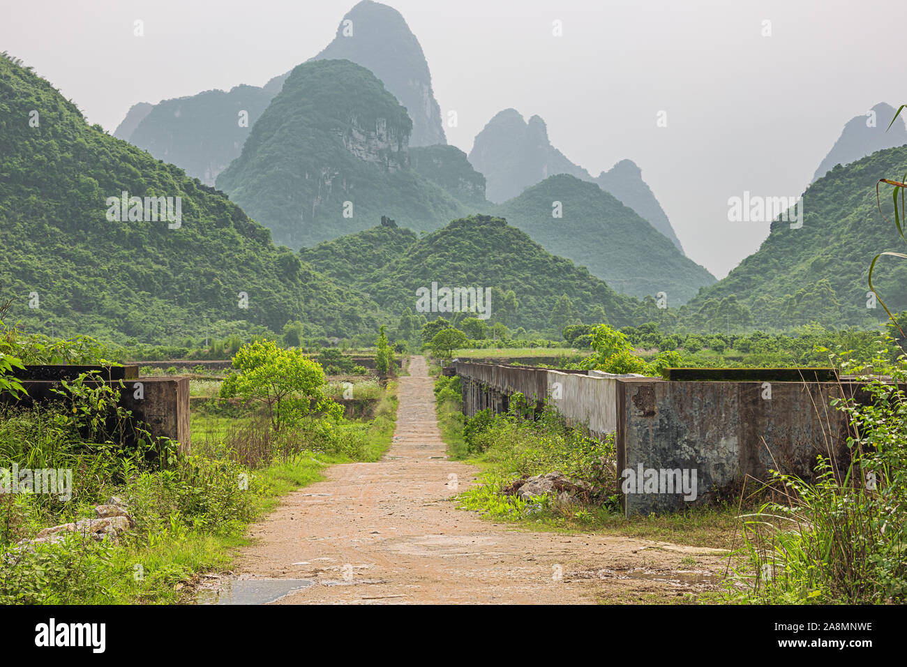 Small road through farmland in the karst hills in the vicinity of Yangshuo near Guilin Stock Photo