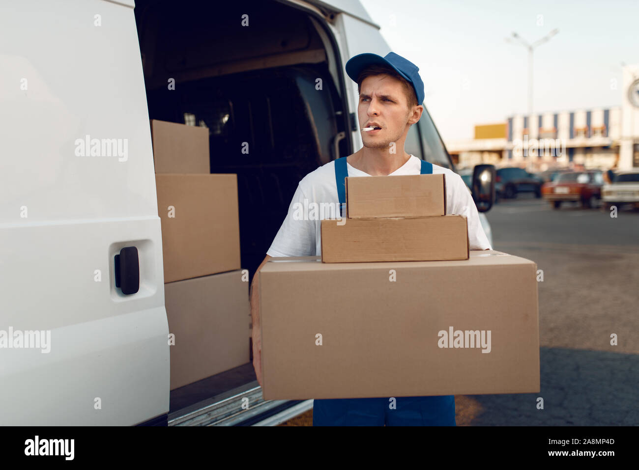 Loader holding stack of parcels, delivery service Stock Photo - Alamy
