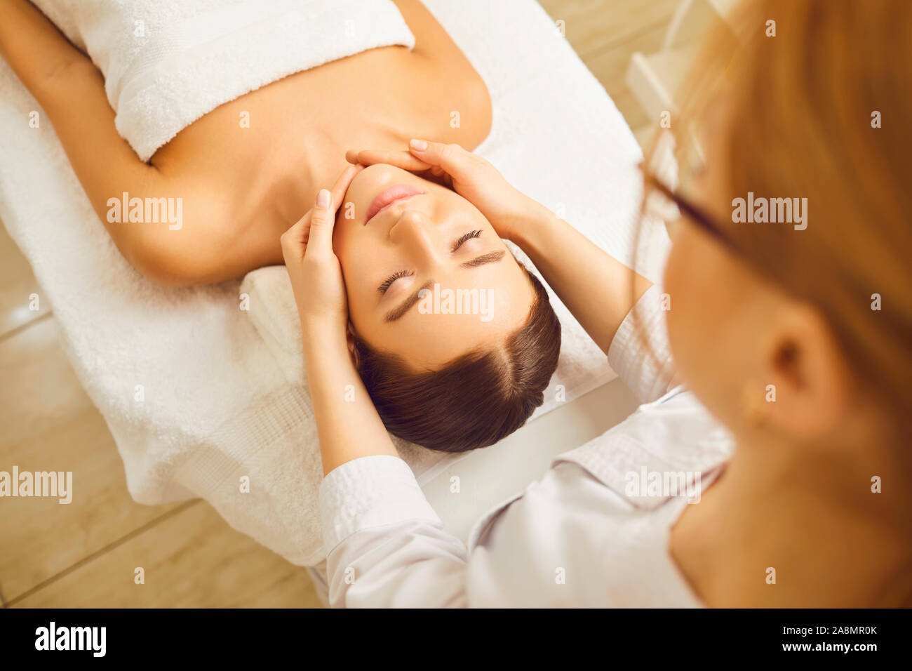 Face massage to young woman close up. Stock Photo