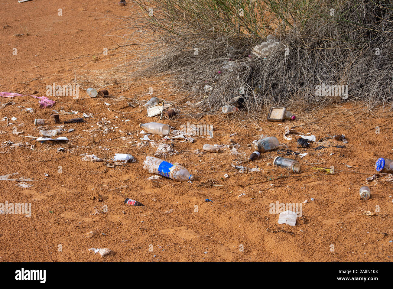 Plastic pollution in the desert sand. Need for awareness of enviornmental protection, recycling, and protecting the world. Environmental concept. Stock Photo