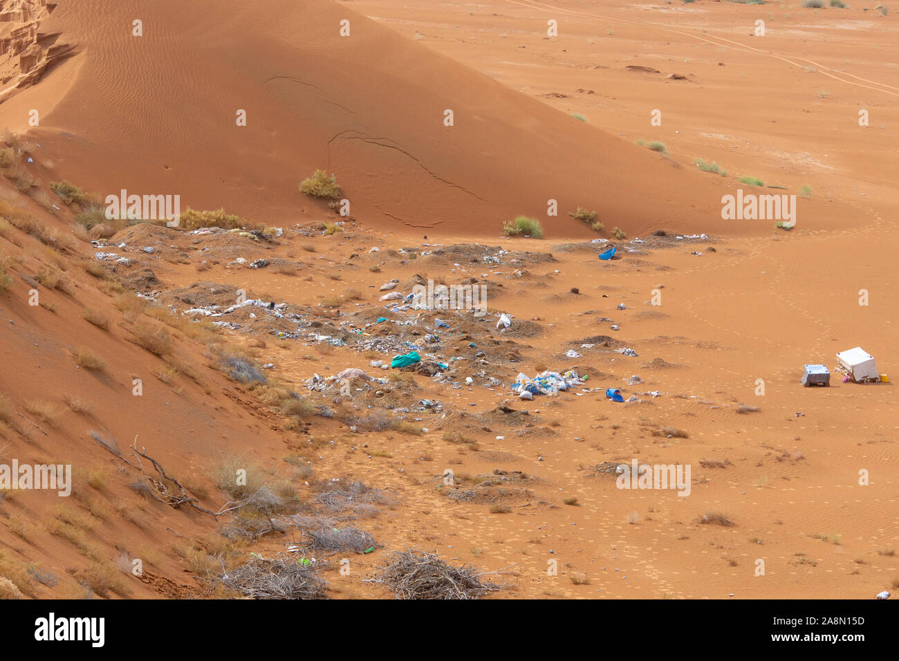 Plastic pollution and garbage dumping in the desert sand. Need for awareness of enviornmental protection, recycling, and protecting the world. Environ Stock Photo