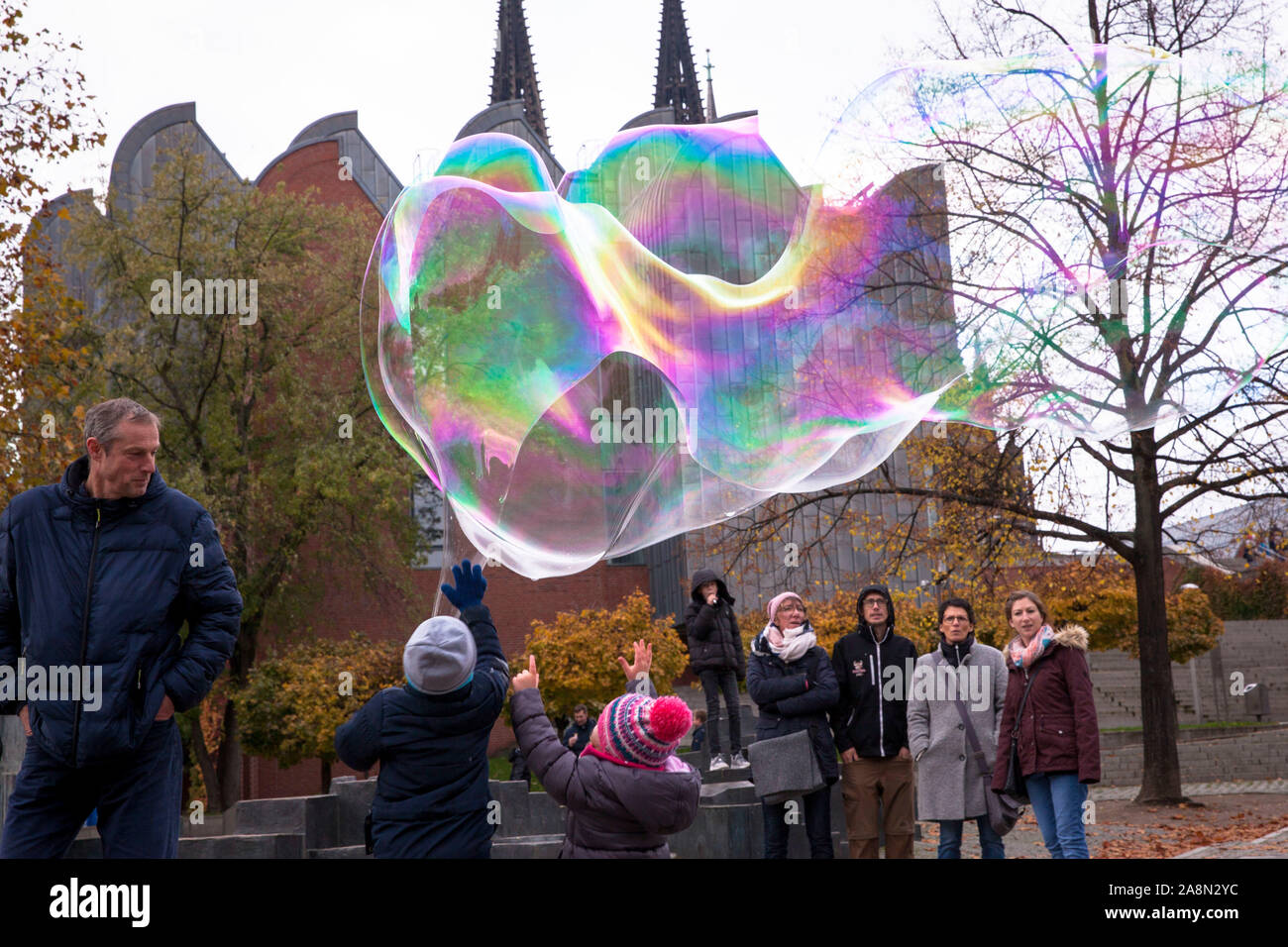 man makes huge soap bubbles at the Rhine garden in the old part of the town, Cologne, Germany.  Mann macht grosse Seifenblasen im Rheingarten in der A Stock Photo