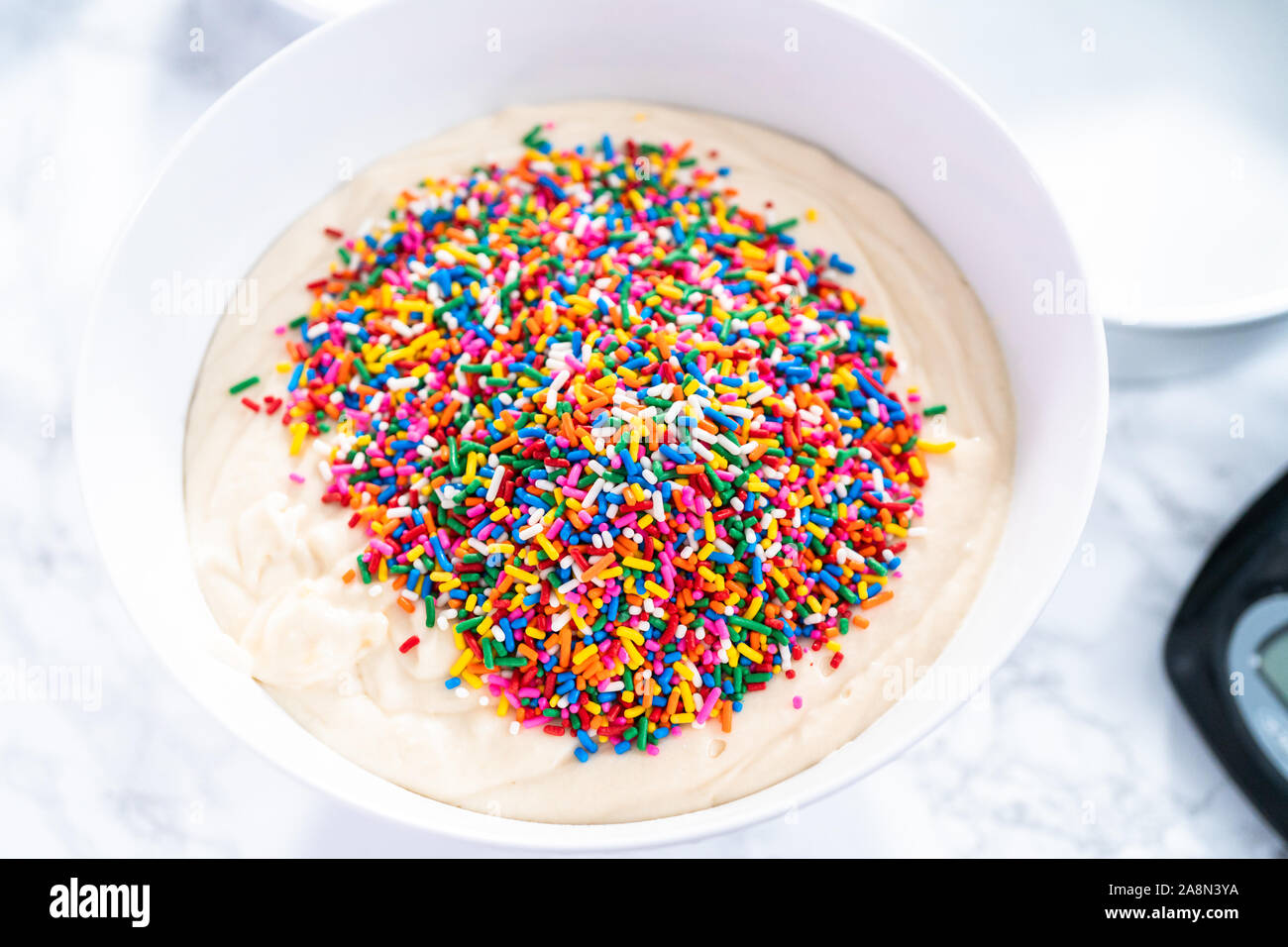 Mixing ingredients to bake birthday funfetti cake with colorful
