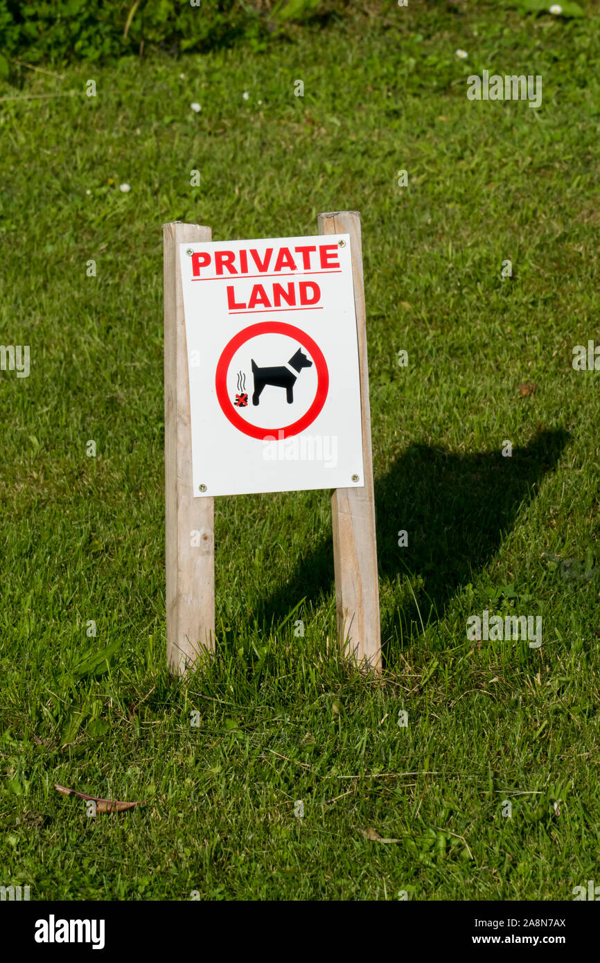 Hinweis Schild auf dem Rasen, Hunde hier nicht scheißen, mit der englisches Aufschrift PRIVATE LAND Stock Photo