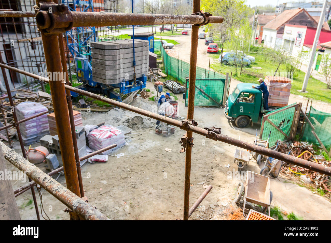 Rusty scaffold is placed against edifice, building under construction ...