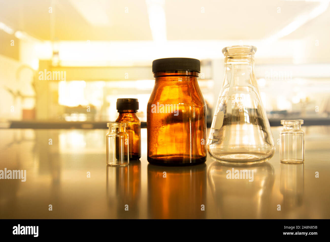 science flask and brown bottle in vintage pharmacy laboratory with soft light background Stock Photo