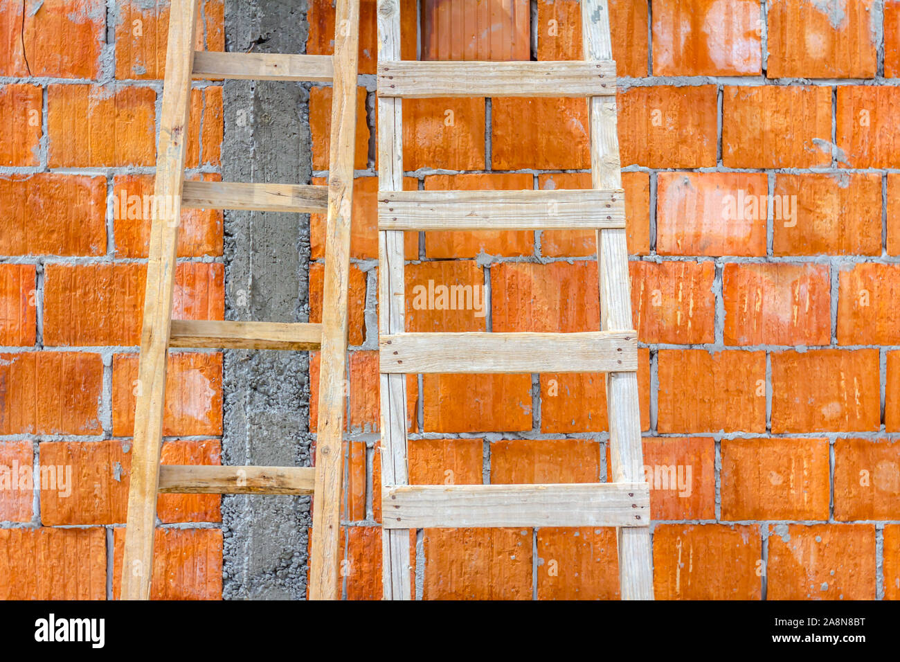 Front view on used wooden ladders, leaning against the wall for access