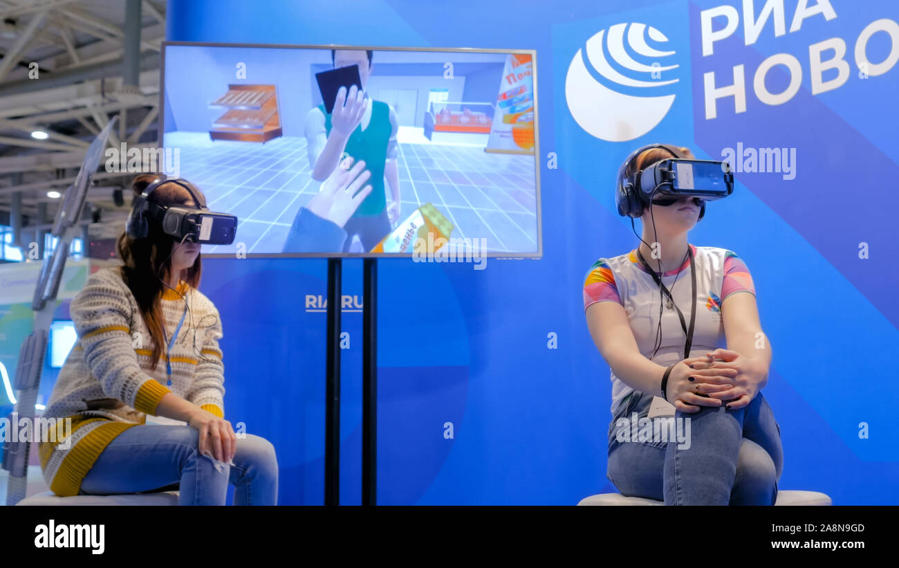 Two women using virtual reality headset and looking around Stock Photo