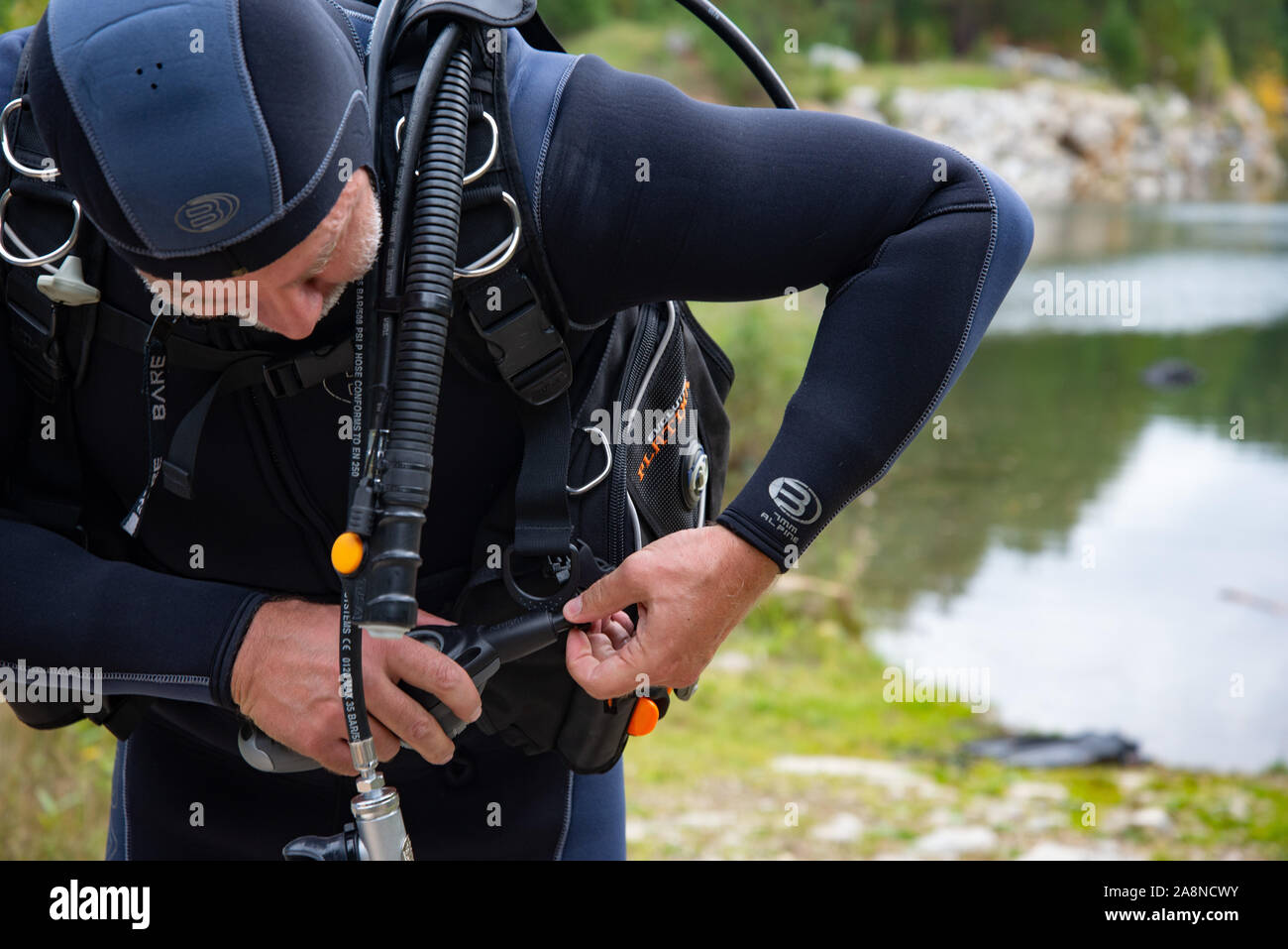 Paayanne lake, Finland - September 2019. Diver checks equipment near the lake. Male diver in wetsuit checking equipments before immerse Stock Photo