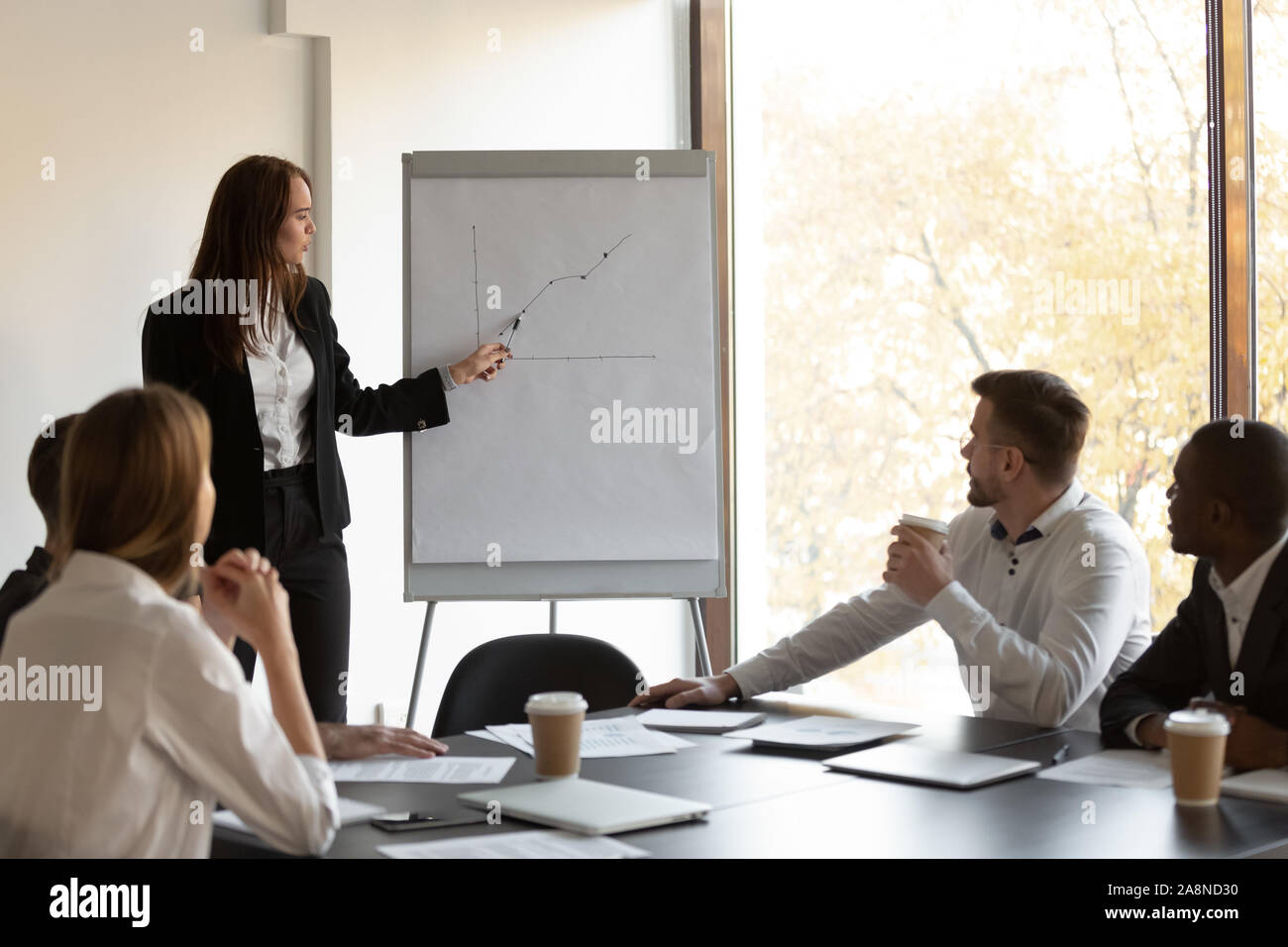 Female financial advisor making whiteboard presentation at briefing Stock Photo