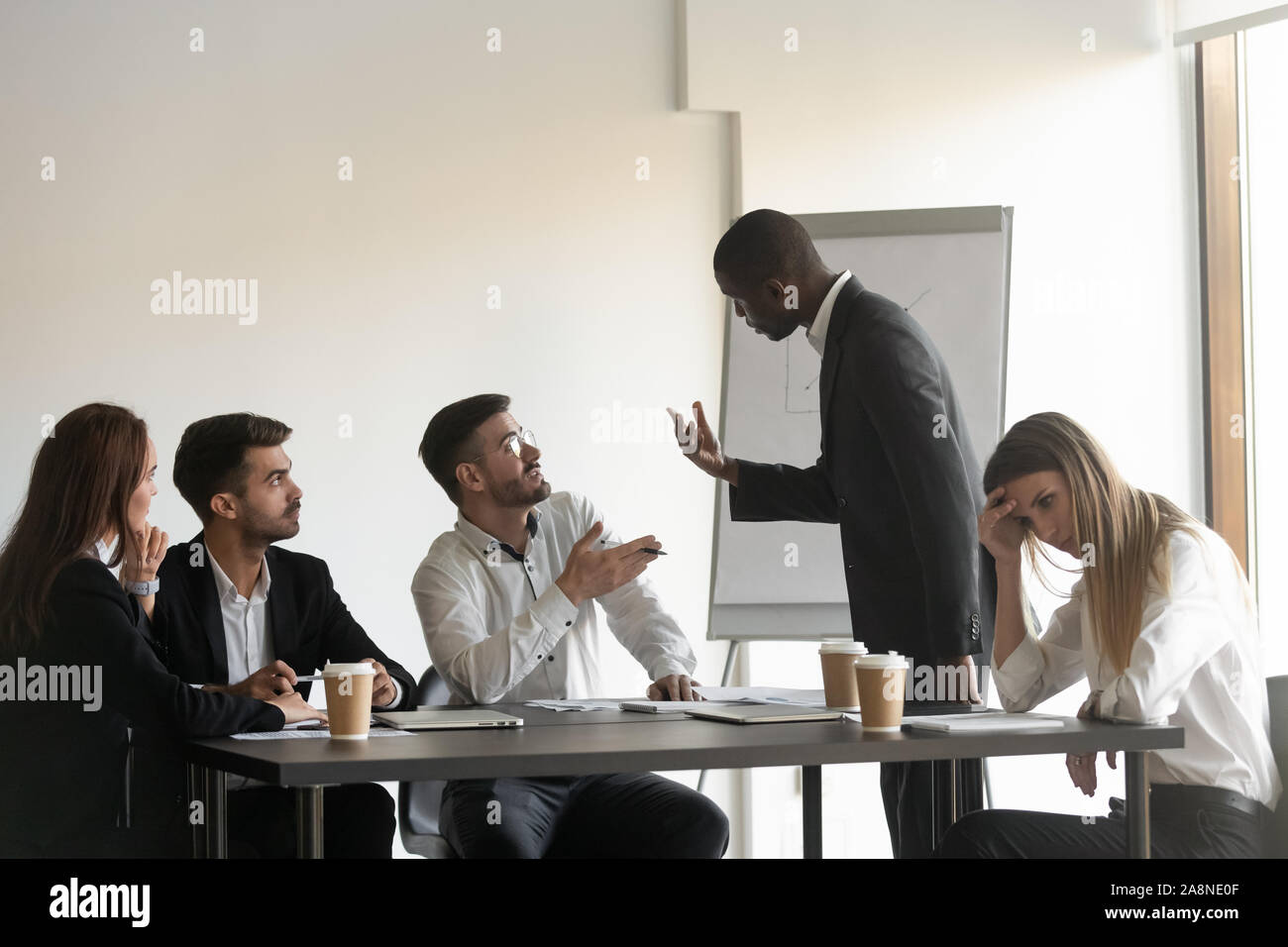 Multiracial colleagues argue at company meeting in office Stock Photo
