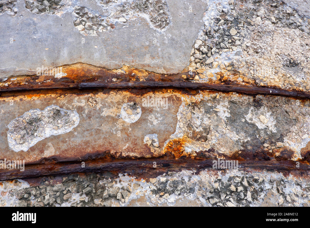 Narrow rusty railway track abstract background, corroded from salt water and abandoned rail transport structure at old sea waterfront. Stock Photo