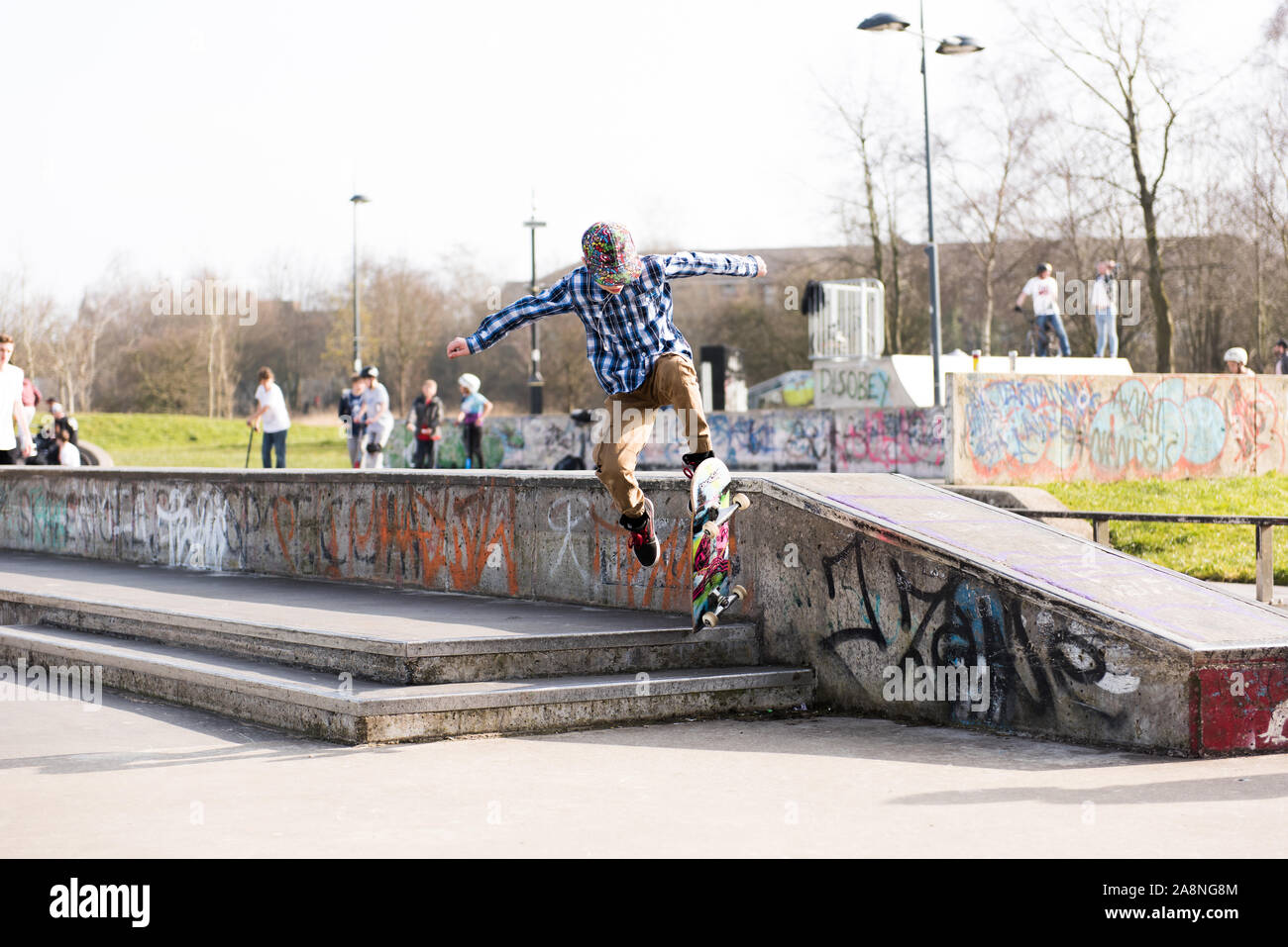A skateboarder Ollie's off a very high double step at the skate park