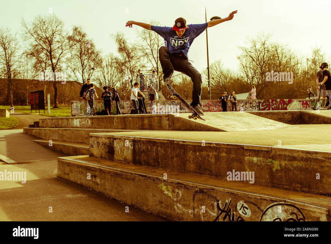 A skateboarder Ollie's off a very high double step at the skate park