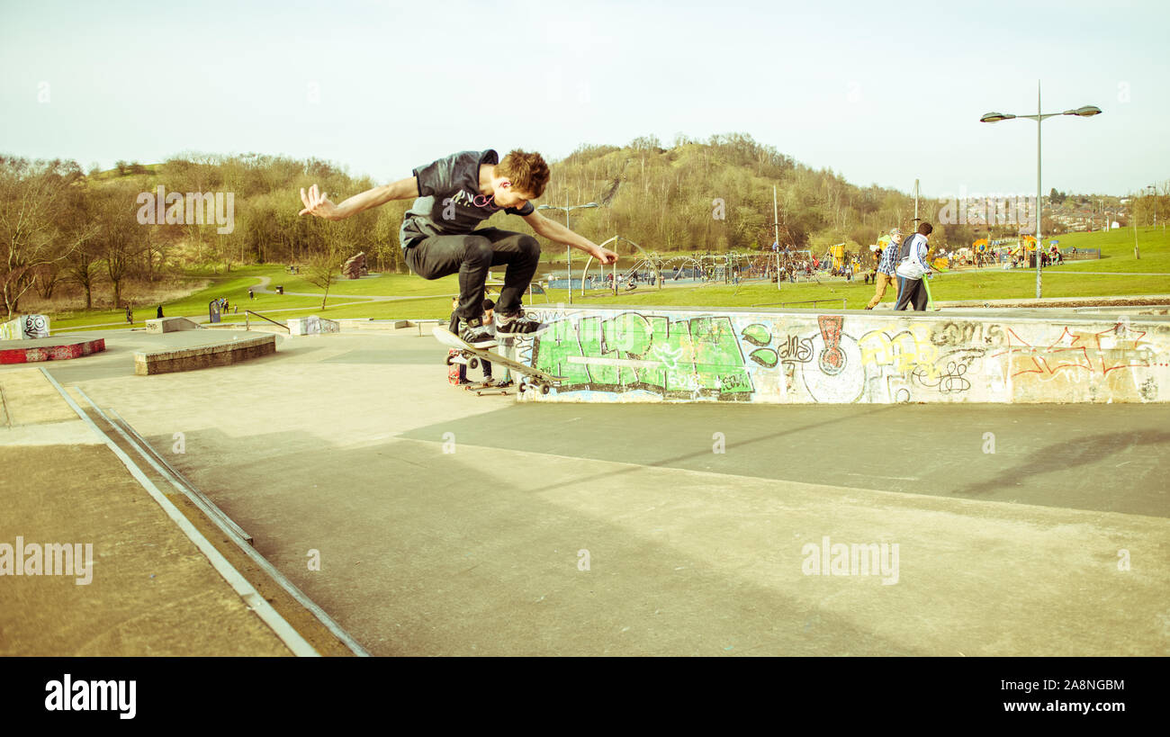 A skateboarder Ollie's off a very high double step at the skate park