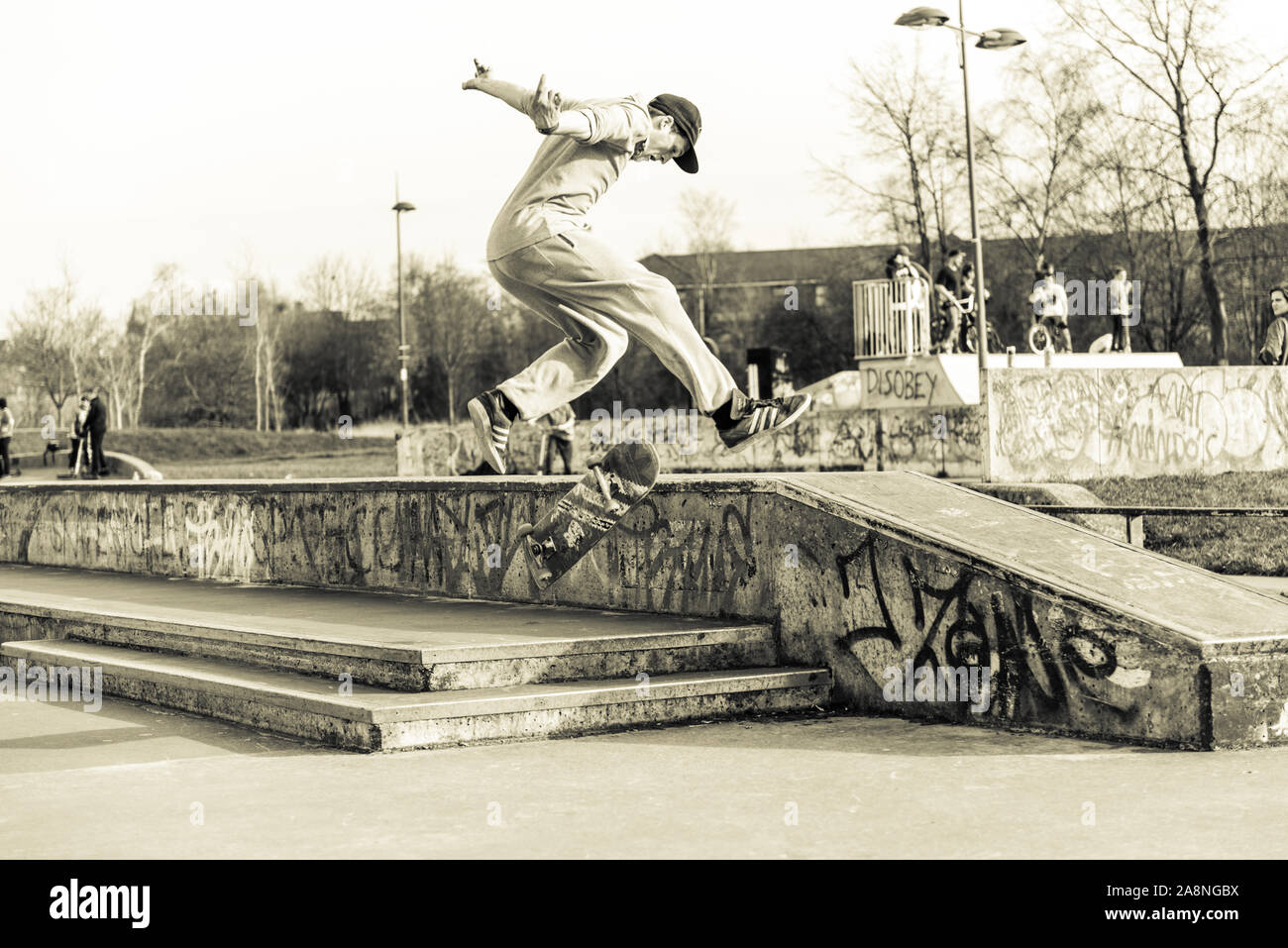 A skateboarder Ollie's off a very high double step at the skate park
