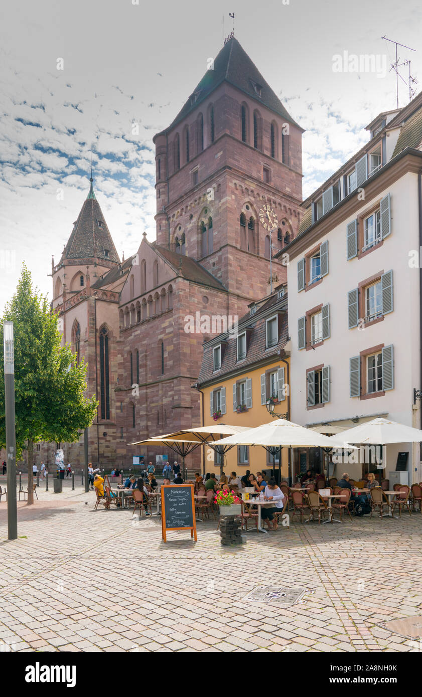 Strasbourg, Bas-Rhin / France - 10 August 2019: people enjoying drinks in French cafe outside of Saint Thomas' Church in the old city center of Strasb Stock Photo