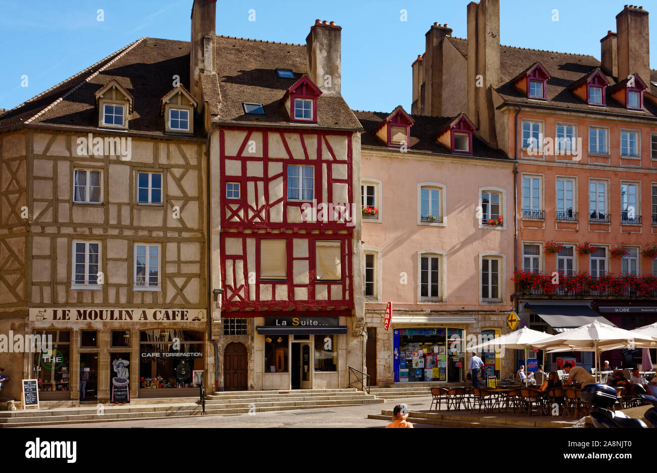 cityscape, old half-timbered buildings, outdoor tables, chairs, umbrellas, people, shops, cafe, sloped street, Burgundy; Chalon sur Soane; France; sum Stock Photo