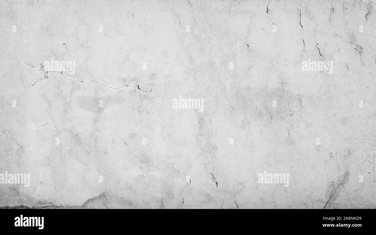 Close-up of an aged and cracked smooth natural marble stone wall or flooring. High resolution full frame textured background in black and white. Stock Photo