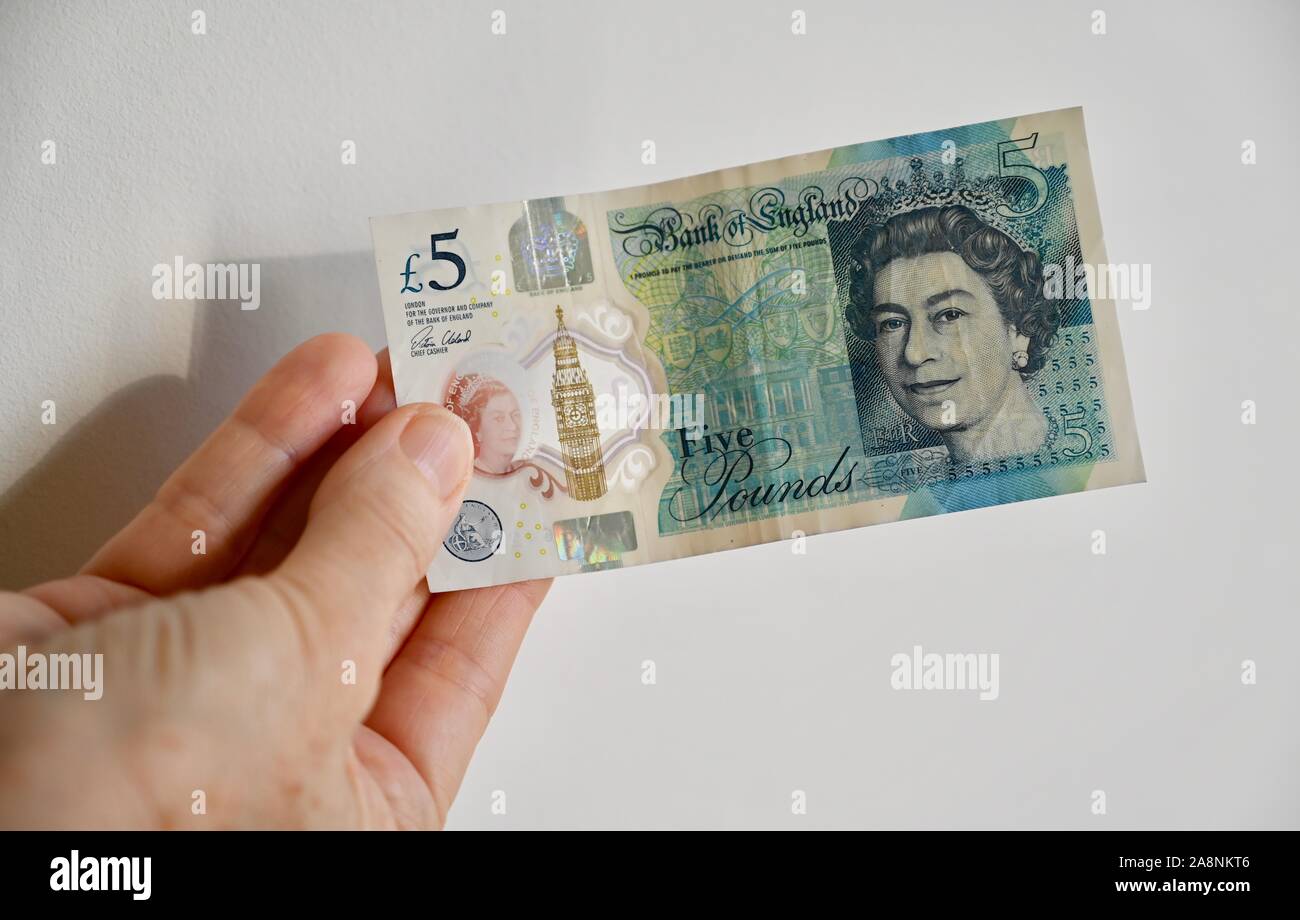 Close up of women holding a five pound note. Stock Photo