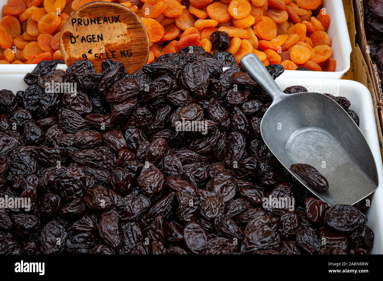 dried prunes on french market stall, with apricots in background