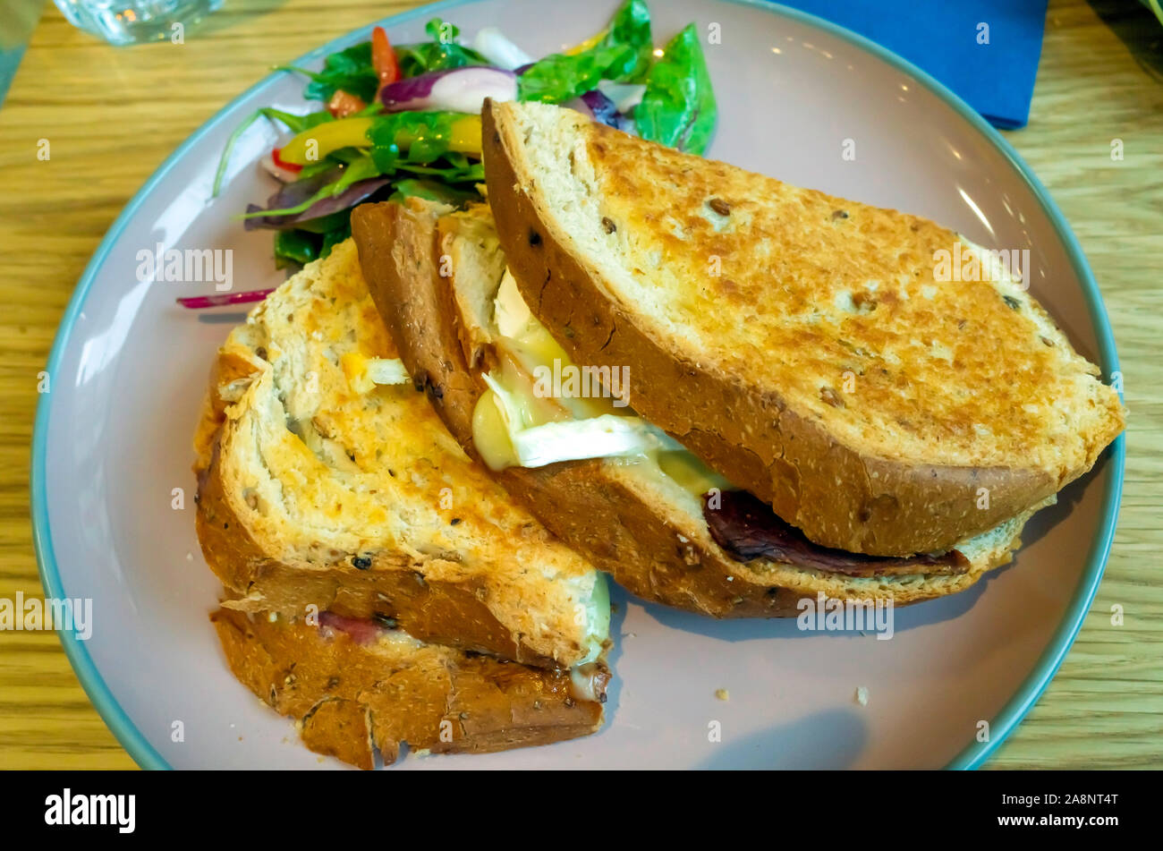 Lunch snack Bacon and Brie sandwich on granary Bread with salad leaves Stock Photo