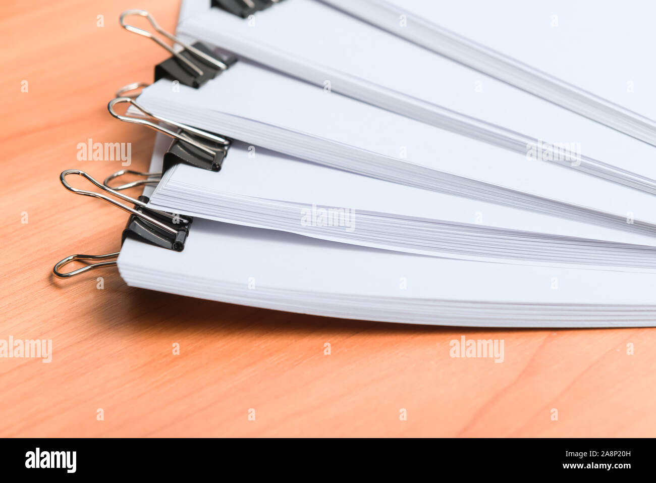 Many printed paper documents with black clips on wooden table Stock Photo