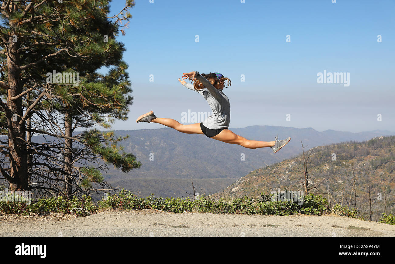 Young athletic woman does split  leap in the mountains of Kings Canyon National Park. Stock Photo