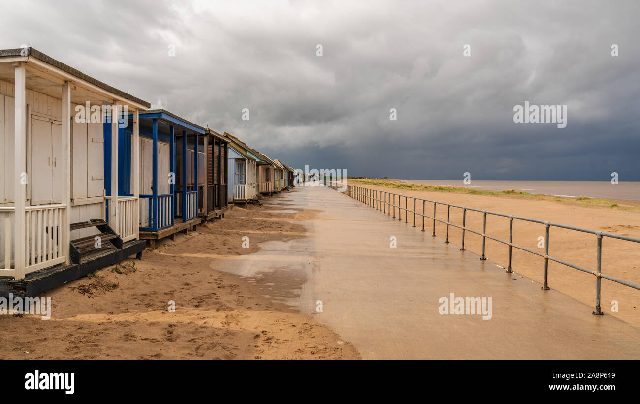 Grey clouds over the Beach Huts in Sandilands, Lincolnshire, England, UK Stock Photo