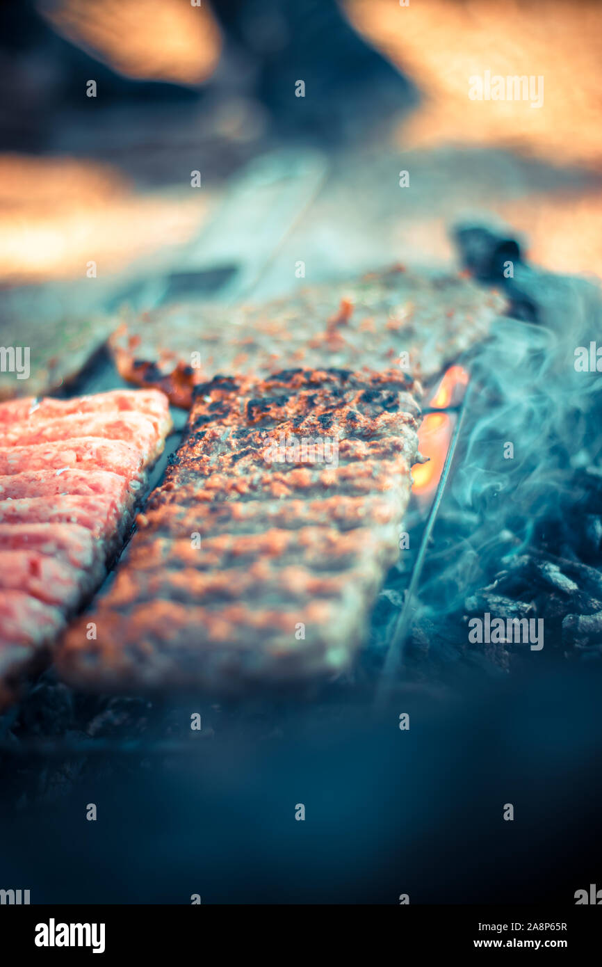Balkan cuisine, pork beef cevapi,cevapcici. Minced meat sticks. Grilling on open flame in nature Stock Photo