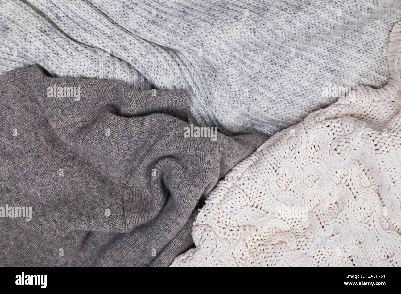 Warm knitted sweaters lying close, top view. Stock Photo