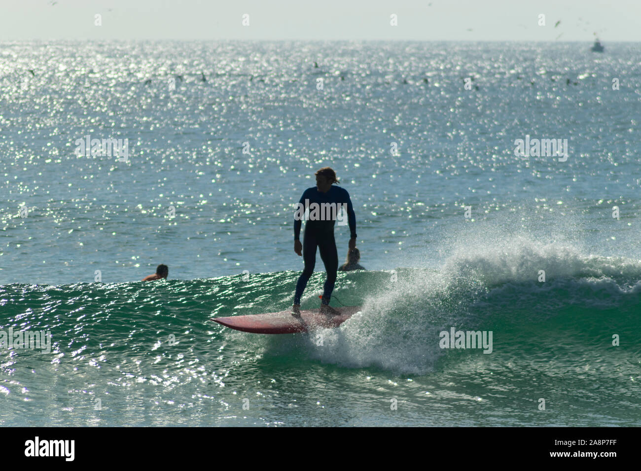 Surfers on Supertubos - a popular beach with surfers in Peniche Portugal Stock Photo