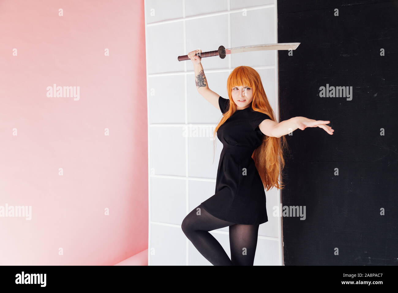 woman anime cosplayer with red hair Japanese sword Stock Photo