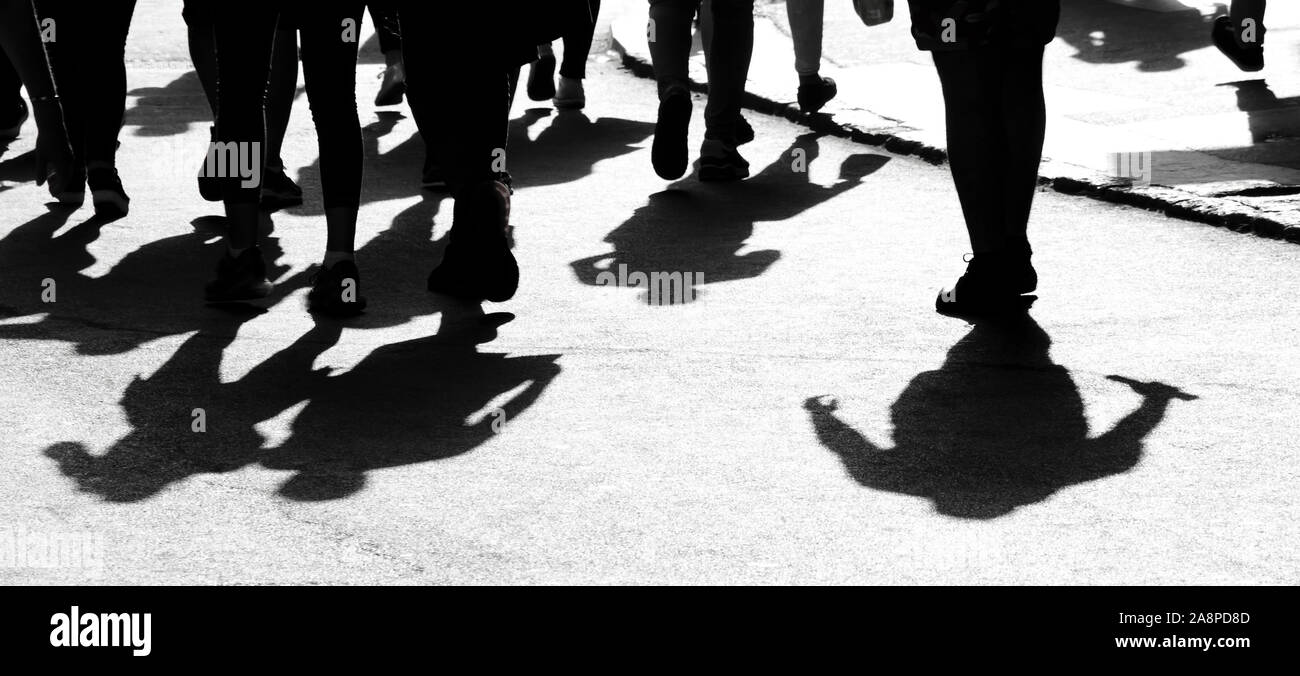 Blurry shadow silhouette of people walking on city pedestrian street in ...