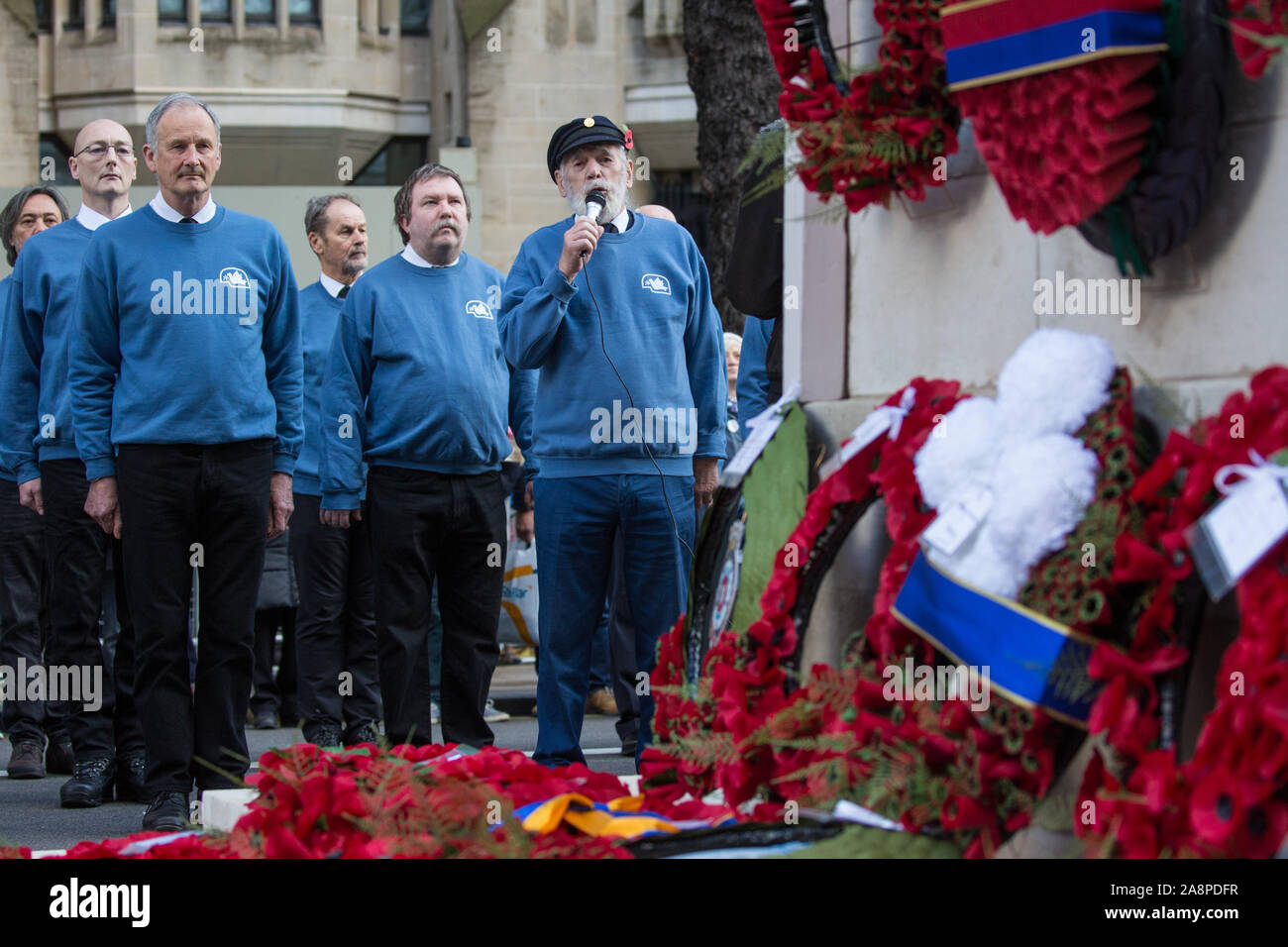 London, UK. 10 November, 2019. Jim Radford (c), D-Day veteran and folk singer, sings ‘1916’ in front of ex-services personnel from Veterans For Peace UK (VFP UK) taking part in the Remembrance Sunday ceremony at the Cenotaph. VFP UK was founded in 2011 and works to influence the foreign and defence policy of the UK for the larger purpose of world peace. Credit: Mark Kerrison/Alamy Live News Stock Photo