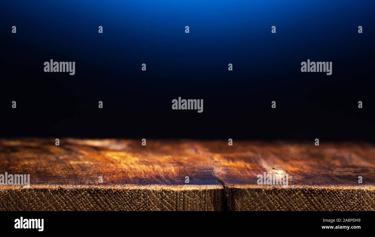 Empty Wooden Table on Dark Blue Background. Backdrop for Product Placement Stock Photo