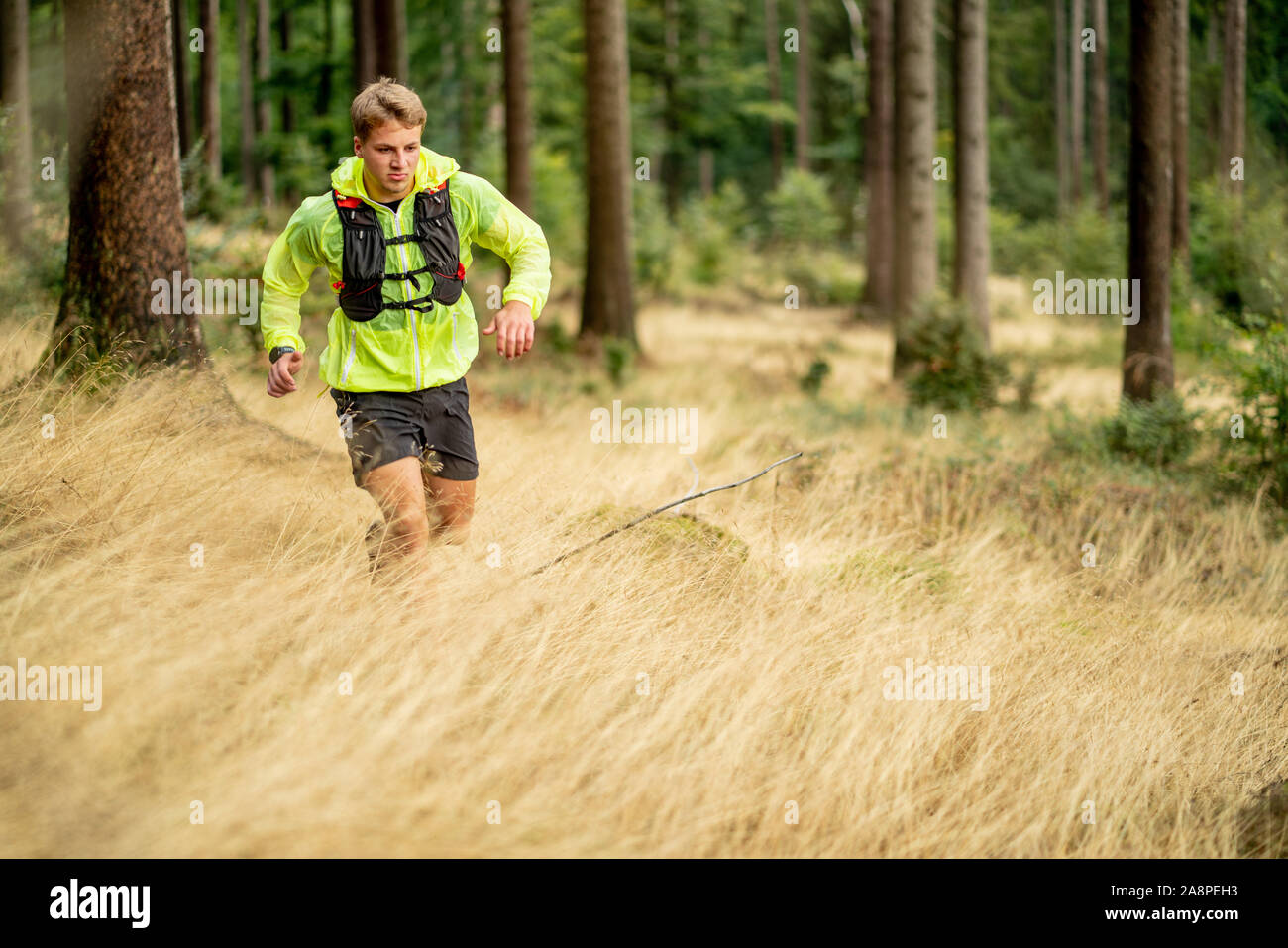 A young athlete in barefoot shoes runs up the mountain. Mountain run