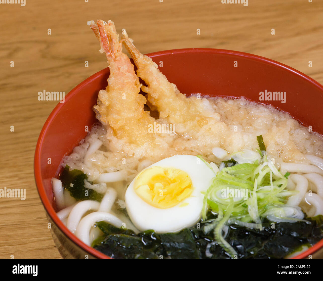 tempura udon with fried shrimps, boiled egg, green algae, leeks, tipical noodles traditional