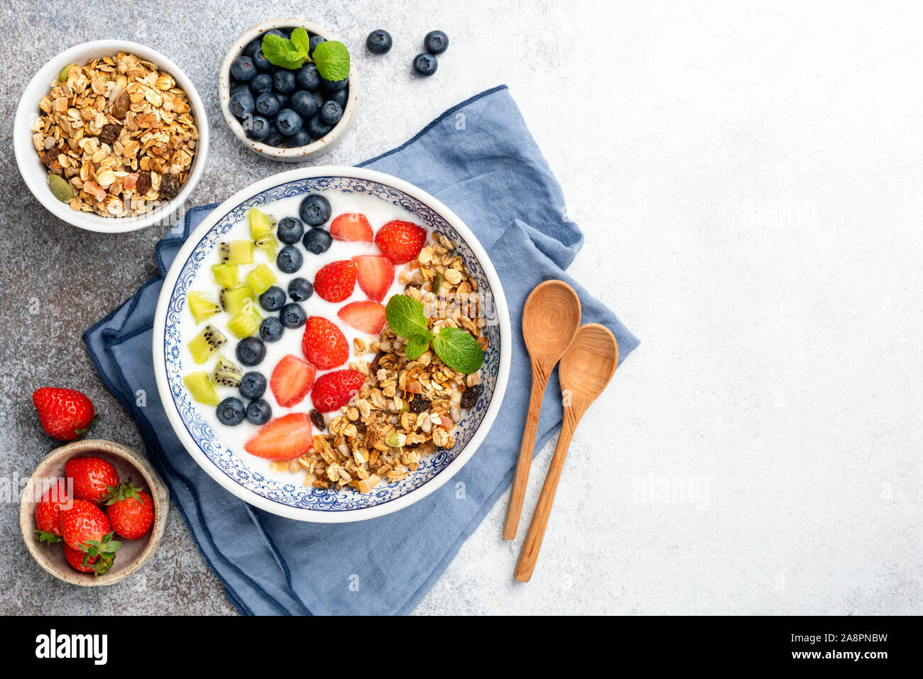 Breakfast yogurt bowl with granola, berries and fruits. Table top view