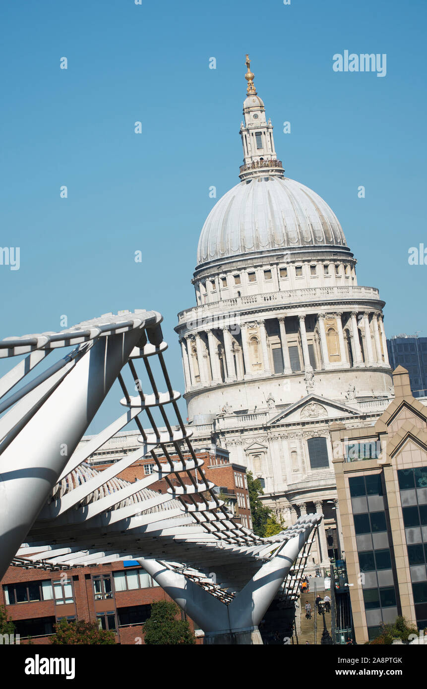 The weathered old dome of Saint Paul's Cathedral contrasts with modern lines of Millennium Bridge London Stock Photo