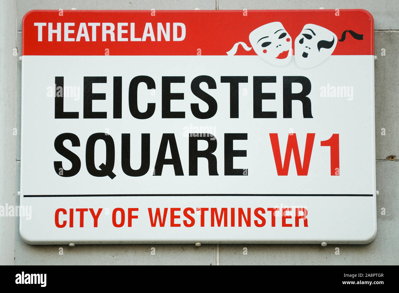 LONDON - SEPTEMBER 29, 2011: Red and black City of Westminster sign for Leicester Square features a Theatreland designation with theatrical masks. Stock Photo